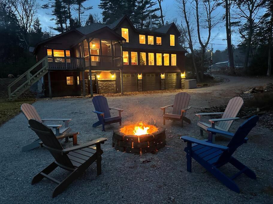 un grupo de sillas sentadas alrededor de un fuego frente a una casa en Redwood - Lakeside Cabin, en Bradford
