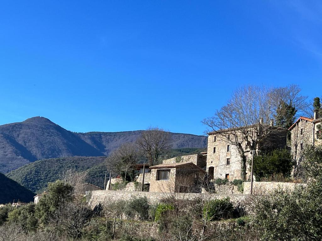 an old building on a hill with mountains in the background at Mas Daudé in Valleraugue