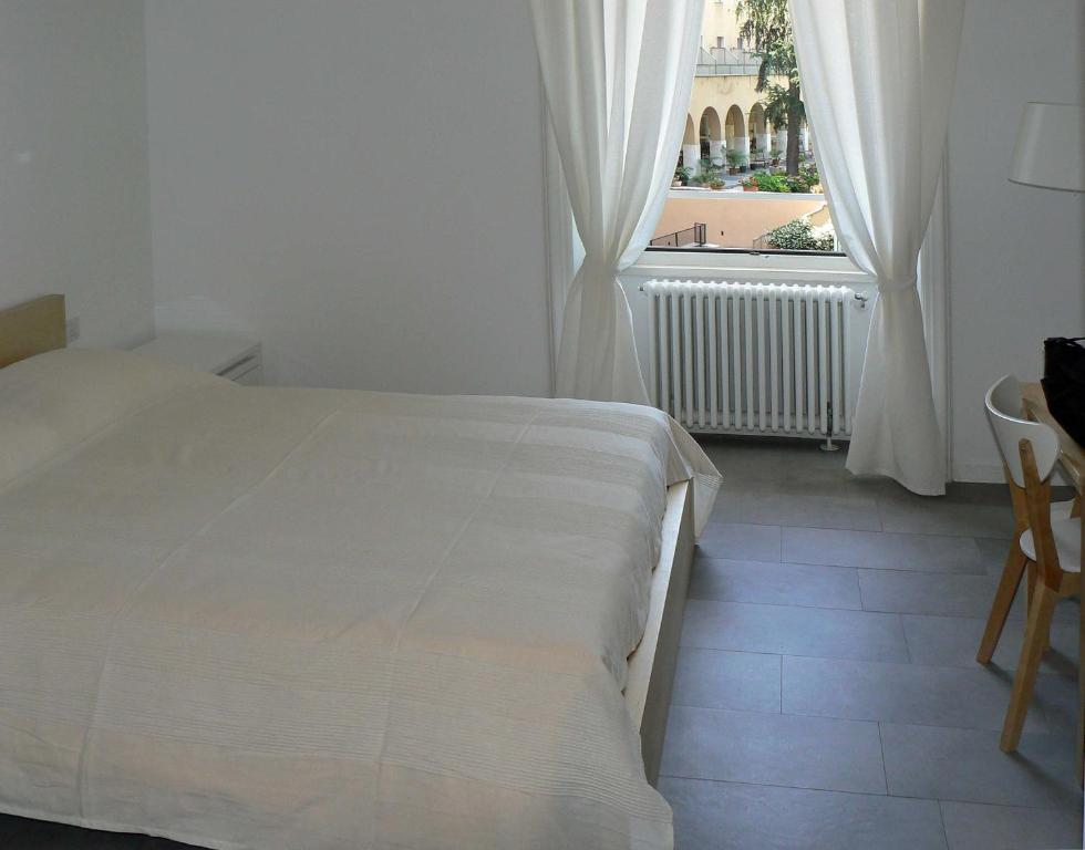 Cama blanca en habitación con ventana en B&b Il Sampietrino Dei Cavalleggeri, en Roma