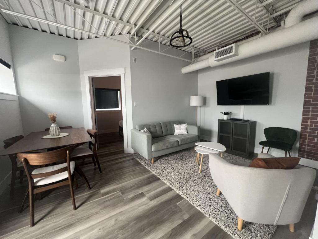 a living room with a table and a dining room at Station 1 by Terra Hospitality in Moncton