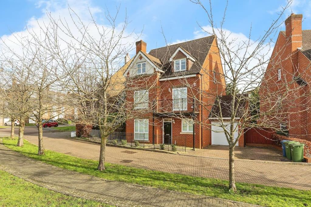 a red brick house with trees in front of it at Modern 5 Bedroom House with Free Parking. Only 30 mins to Bond Street in Stanmore