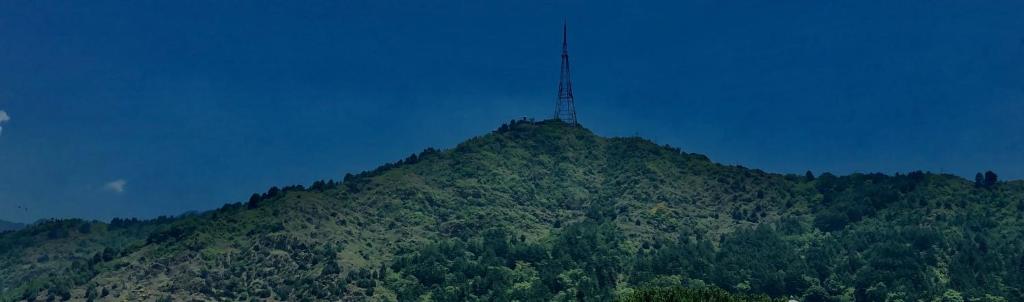 a mountain with a tower on top of it at Hotel Crescent in Srinagar