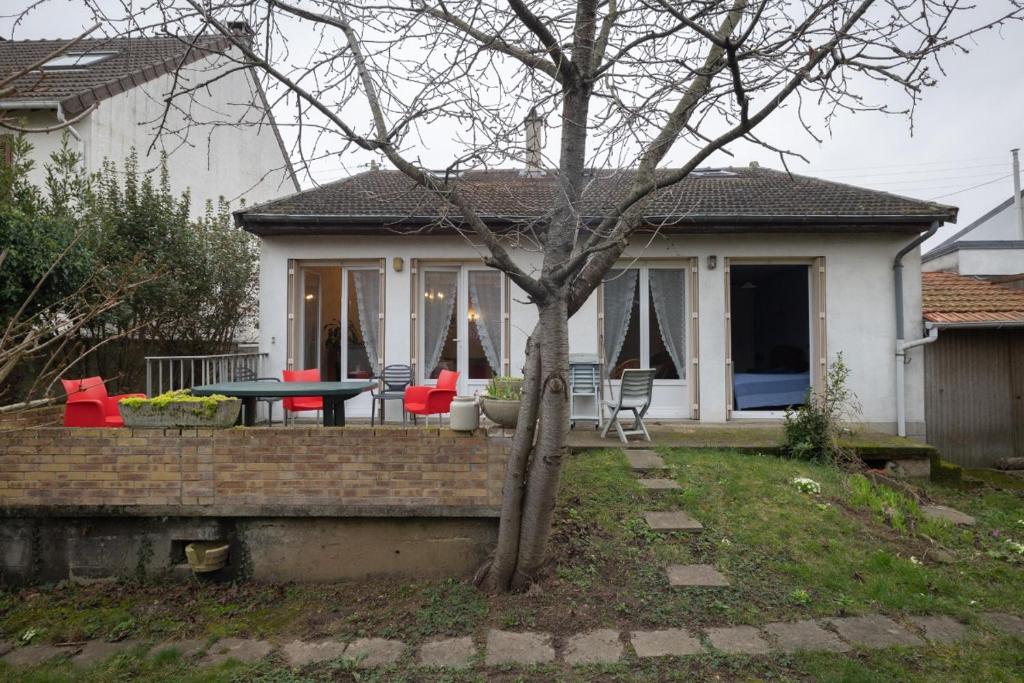 Cette maison dispose d'une terrasse avec une table et des chaises. dans l'établissement LE COTEAU Pavillon au calme 2 chambres 4-5 personnes, à Savigny-sur-Orge