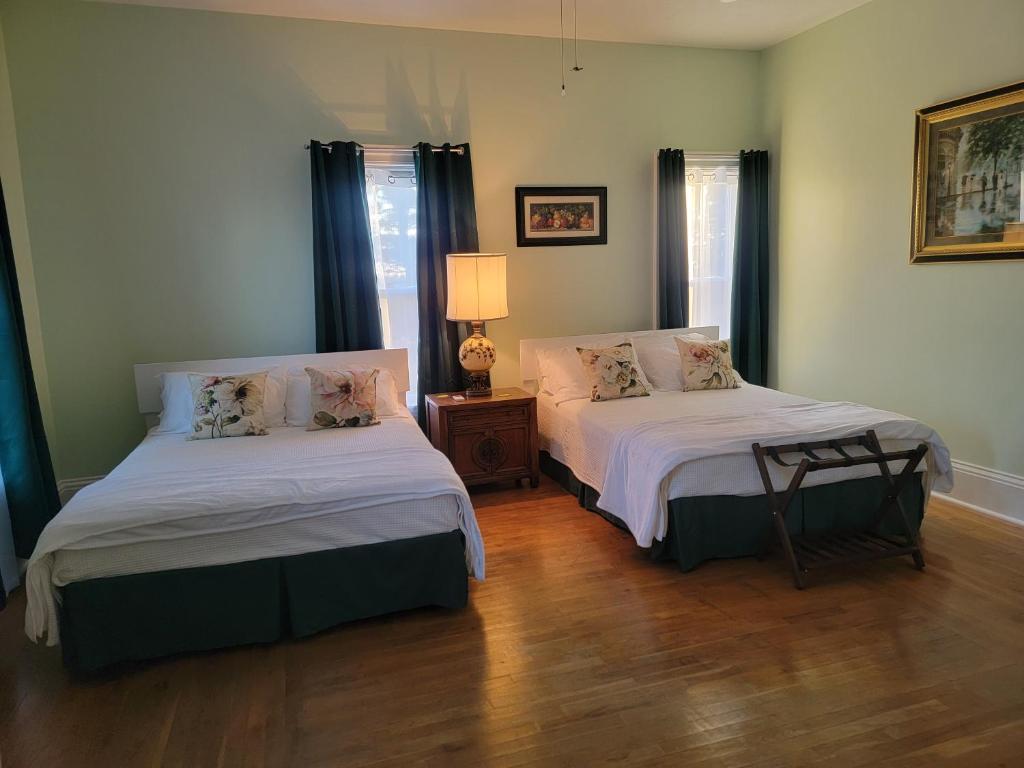 Josephine's Bed & Breakfast في Titusville: غرفة نوم بسريرين ومصباح