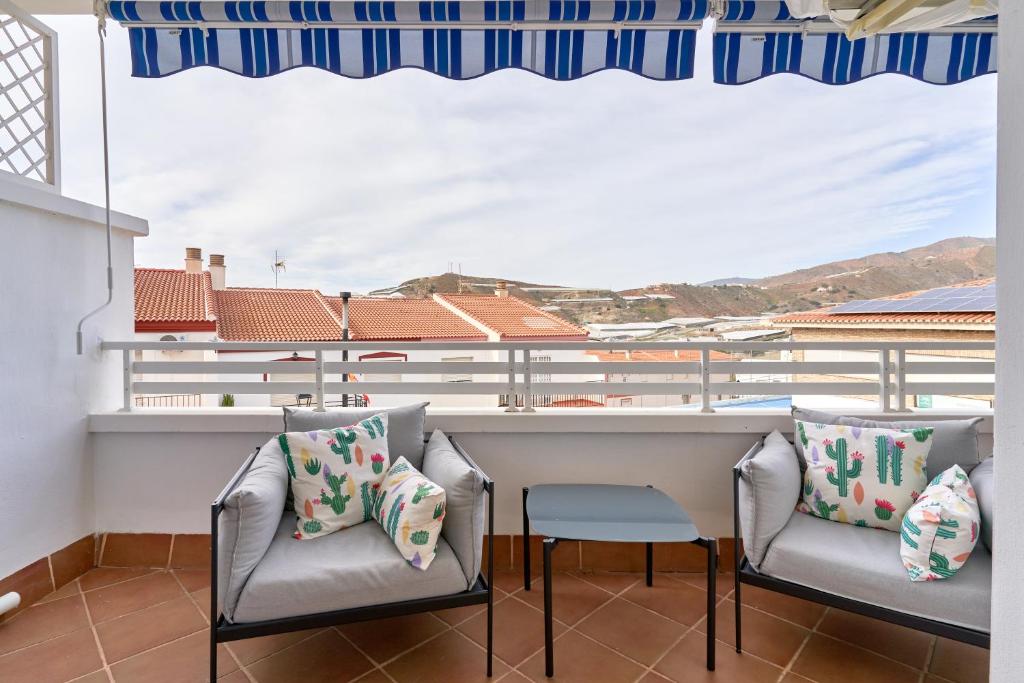 Un balcón con sillas y un bar con vistas. en Bonito Apartamento Costa Tropical, en Polopos