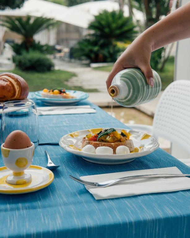 a table with plates of food and a cup of coffee at Relais Corte Degli Aragonesi in Ischia