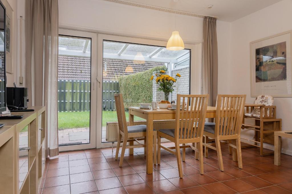 een keuken en eetkamer met een tafel en stoelen bij Haus Harle 50203 Ferienhaus Harle 1 in Harlesiel