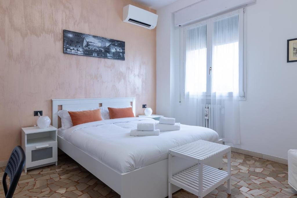 biała sypialnia z dużym białym łóżkiem i oknem w obiekcie HouSmart Galeotti 16 w Bolonii