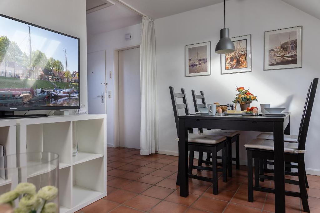 a dining room with a table and a tv at Haus Harle 50205 Ferienwohnung Harle 4 in Harlesiel