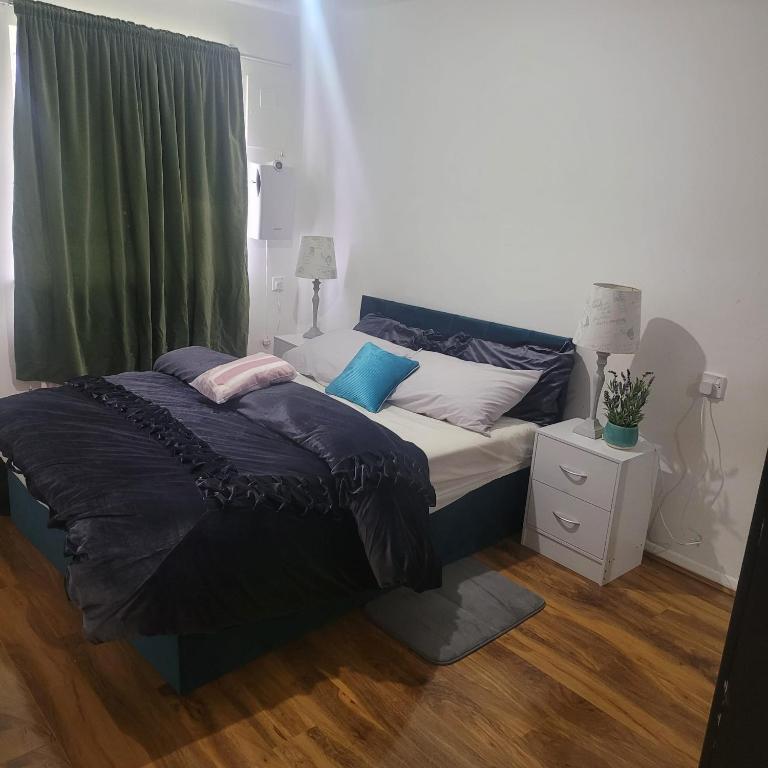 Thamesmead的住宿－Exquisite 3-Bed Royal Pearl Home in Greater London，一间卧室配有一张带蓝色和白色枕头的床