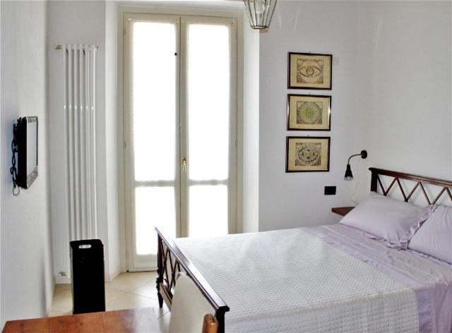 a bedroom with a bed and a large window at La Filanda in Brescia