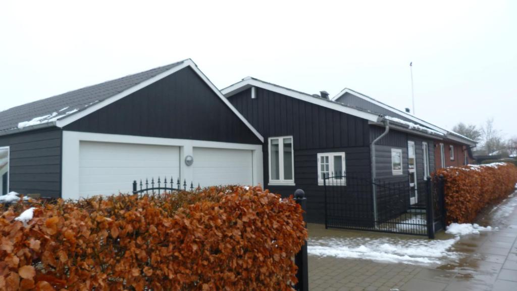a black house with a white garage at (id. 099) Grønnevej 35 in Esbjerg
