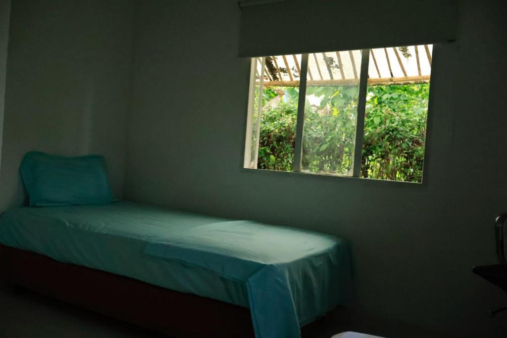 a small bed in a room with a window at Finca Turistica Moniyamena, Encuentro con la Naturaleza in Villavicencio