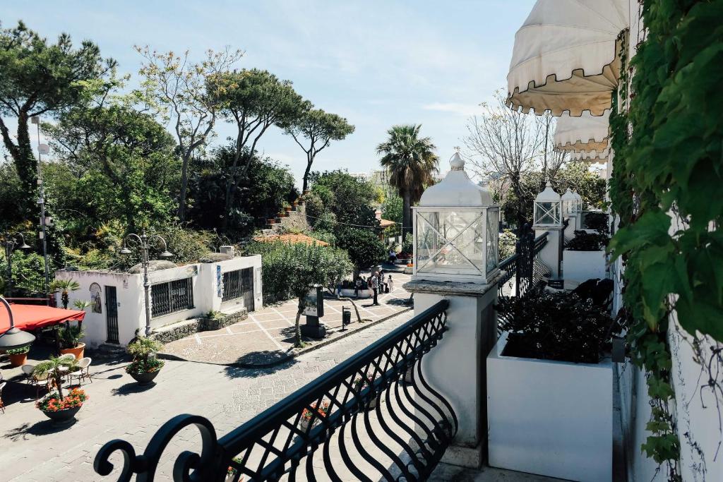 a balcony with a black fence and a street with trees at Relais Corte Degli Aragonesi in Ischia