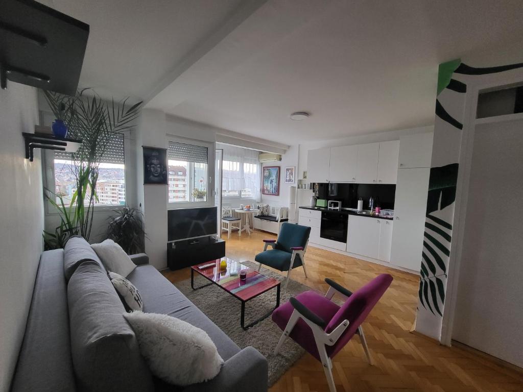 a living room with a couch and chairs and a table at Happy Place in Niš