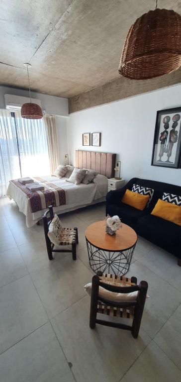 a bedroom with a bed and a table and a couch at Lavalle 12 - Bon Repos in San Miguel de Tucumán