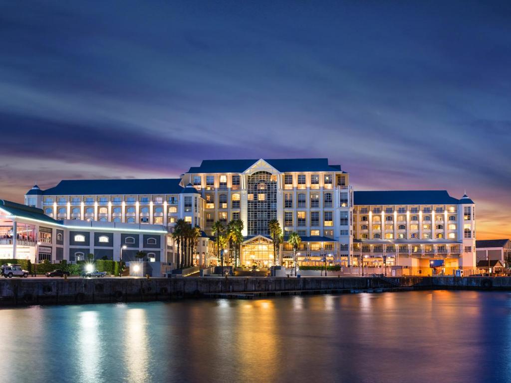 un gran edificio junto a una masa de agua en The Table Bay Hotel, en Ciudad del Cabo