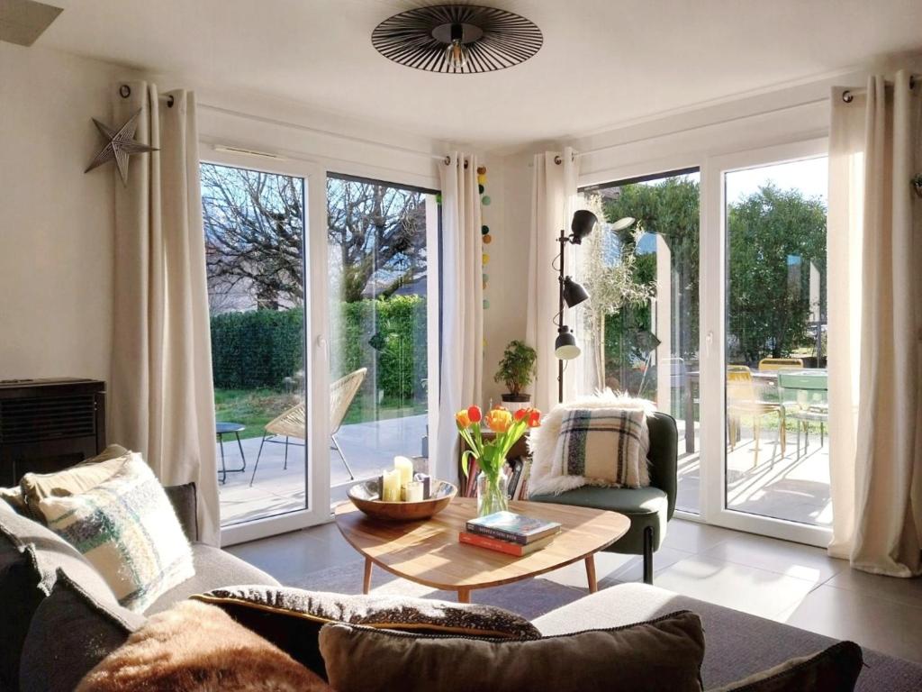 uma sala de estar com um sofá e uma mesa em Villa récente - centre St Jorioz, quartier calme, jardin terrasse, vue montagnes, à 2km du lac em Saint-Jorioz