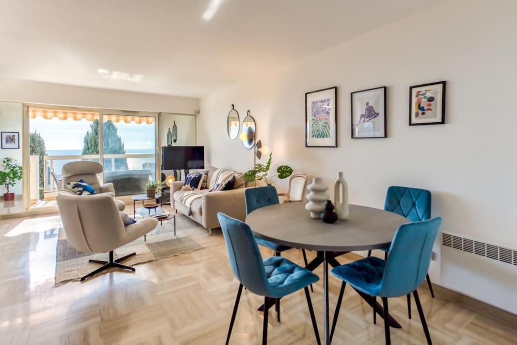 un salon avec une table et des chaises bleues dans l'établissement L11 Claire Fontaine Sea view 2 BDR AC Parking swiming pool, à Nice
