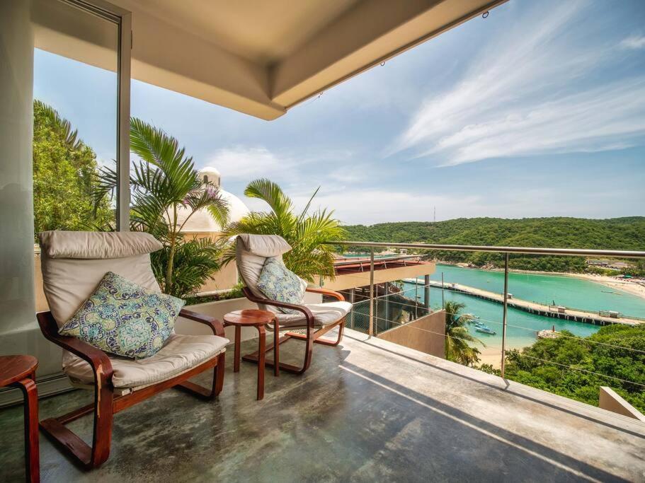 a balcony with chairs and a view of the water at Casa Volare - Contemporary Oceanfront Villa in Santa Cruz Huatulco