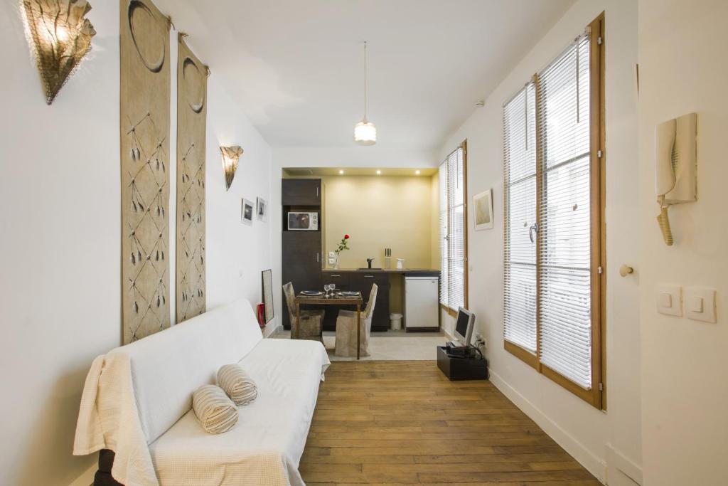 a living room with a white couch and a table at Studio Beaune in Paris