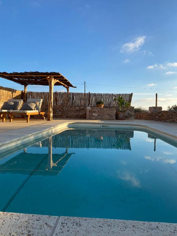 a swimming pool with a pergola next to a patio at Can Mariano Mayans in Sant Francesc Xavier