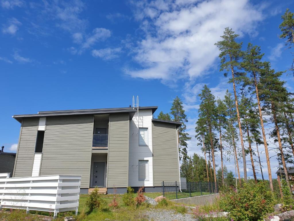 une maison avec une clôture blanche devant elle dans l'établissement Kaksio Kuopion Saaristokaupungissa, à Kuopio