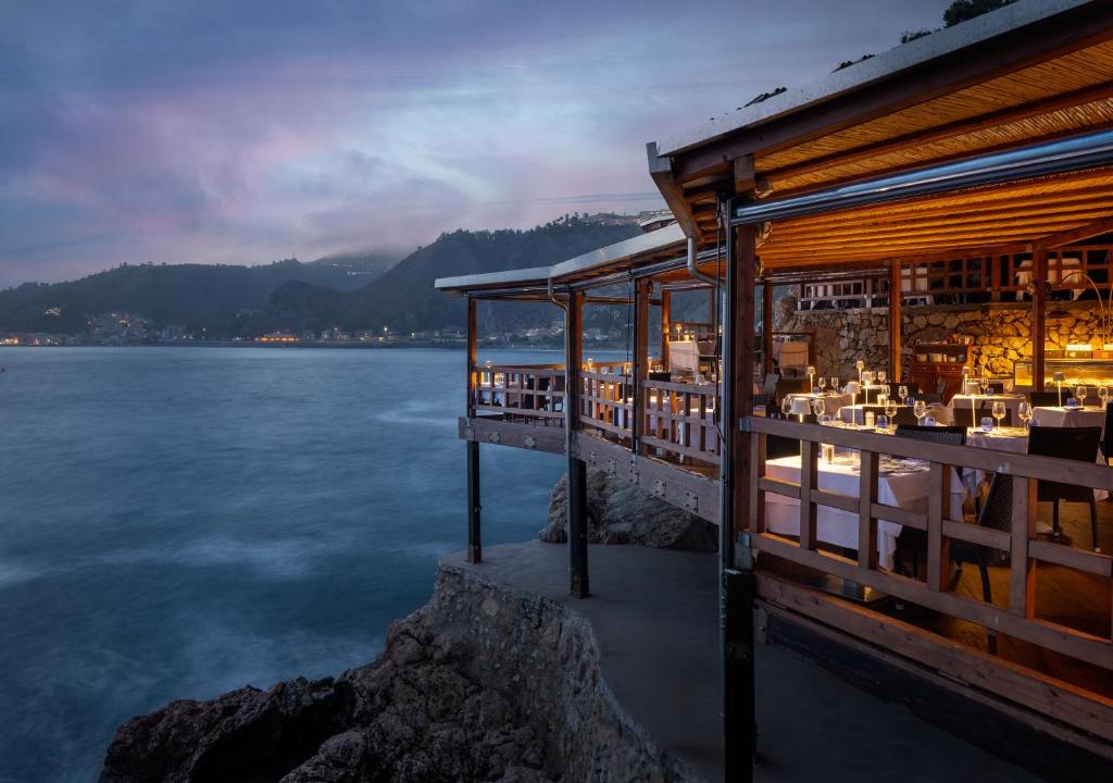 a restaurant on the shore of a body of water at UNA HOTELS Capotaormina in Taormina