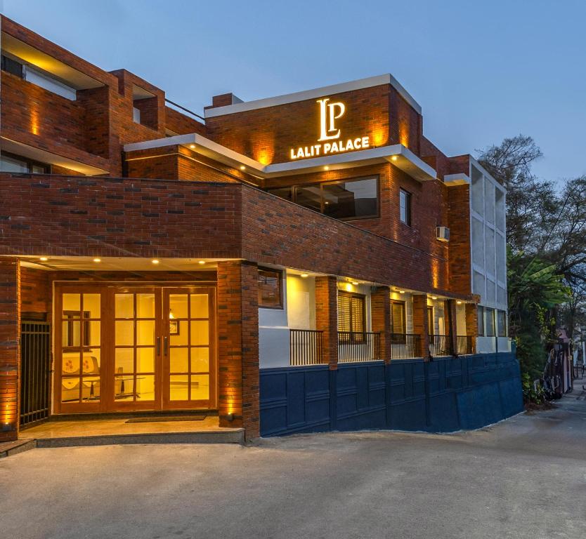 ceglany budynek z parkingiem przed nim w obiekcie Hotel Lalit Palace w mieście Dehradun