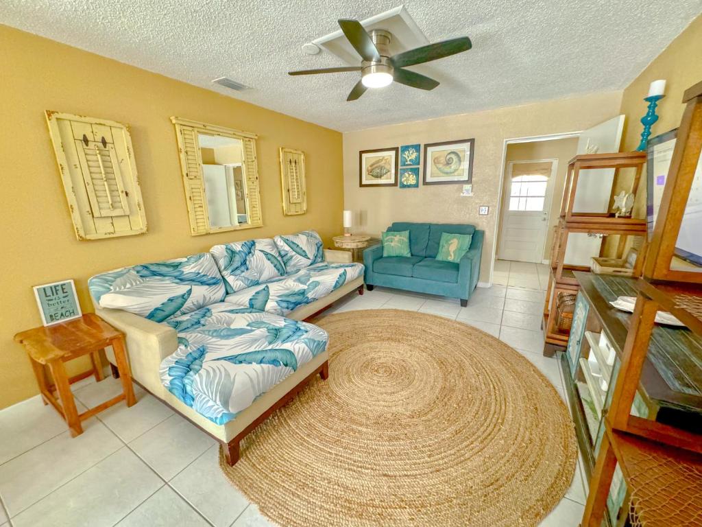 a living room with a couch and a fan at Saltwater Retreat of Redington Shores in St. Pete Beach