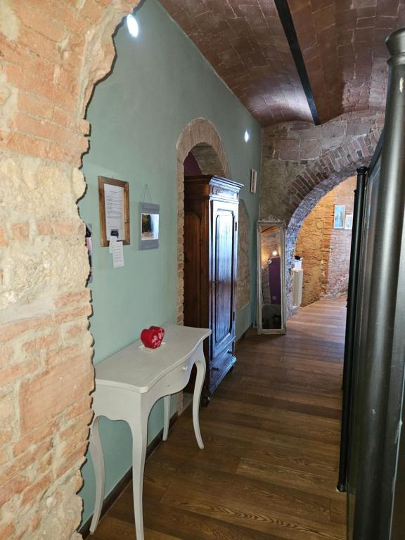 a room with a table and a brick wall at Bella Toscana in Pomarance