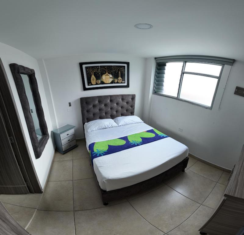 ein Schlafzimmer mit einem großen Bett in einem Zimmer in der Unterkunft Hotel Plaza Paris in Calarcá