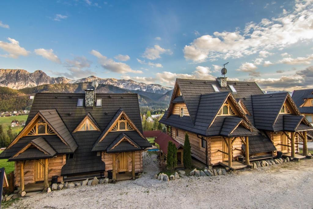 コシチェリスコにあるDomki Tatra Lux Zakopaneの山を背景にした一団の丸太家