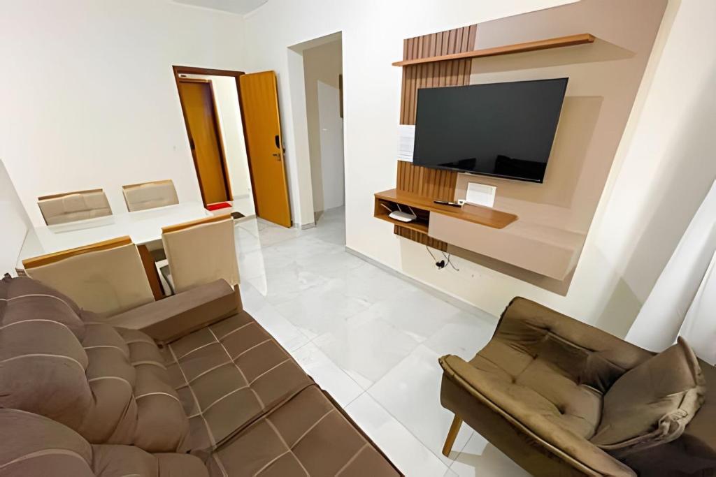 uma sala de estar com um sofá e uma televisão de ecrã plano em 103 - Apartamento Completo Para Até 5 Hóspedes em Patos de Minas
