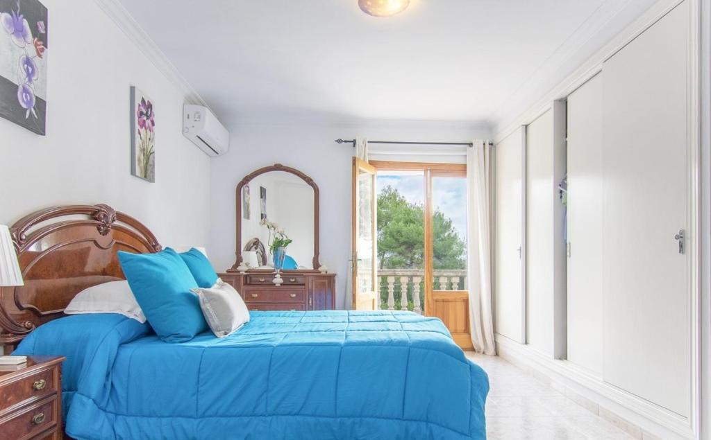 a bedroom with a blue bed and a mirror at Playas de Mallorca in Muro