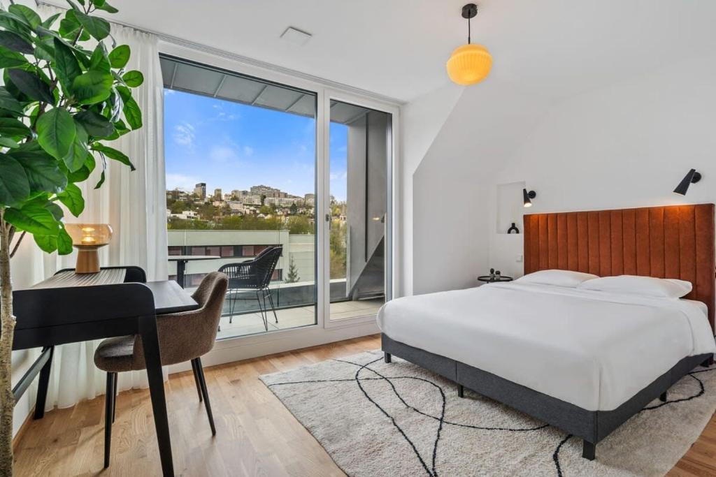 1 dormitorio con cama, escritorio y ventana en New High-End 2 BR Penthouse w Balcony en Luxemburgo