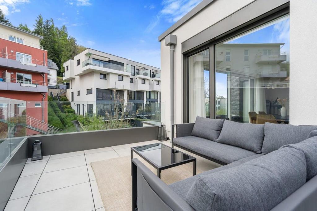 a living room with a couch on a balcony at Luxury 2BR, Free Parking, Balcony in Luxembourg