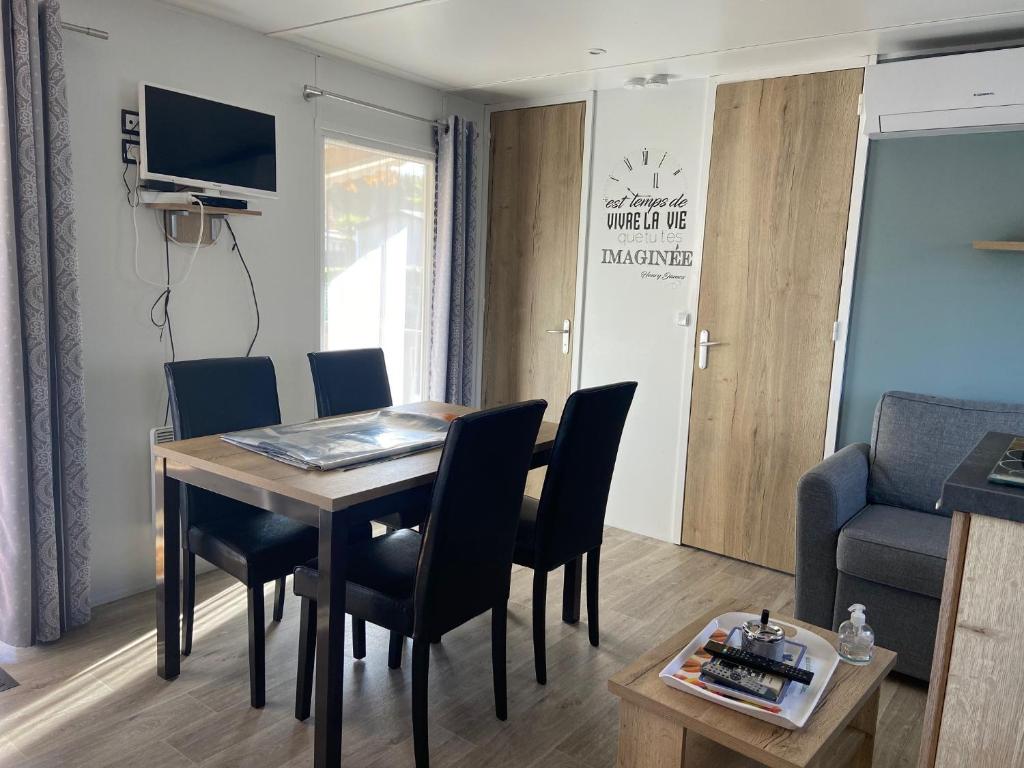 un salon avec une table et des chaises de salle à manger dans l'établissement MOBIL HOME 2 CHAMBRES CLIMATISE, à Gastes
