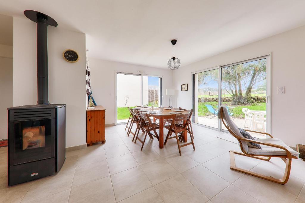 - un salon avec une cheminée, une table et des chaises dans l'établissement Douce escale à Saint-Pierre-Quiberon, à Saint-Pierre-Quiberon