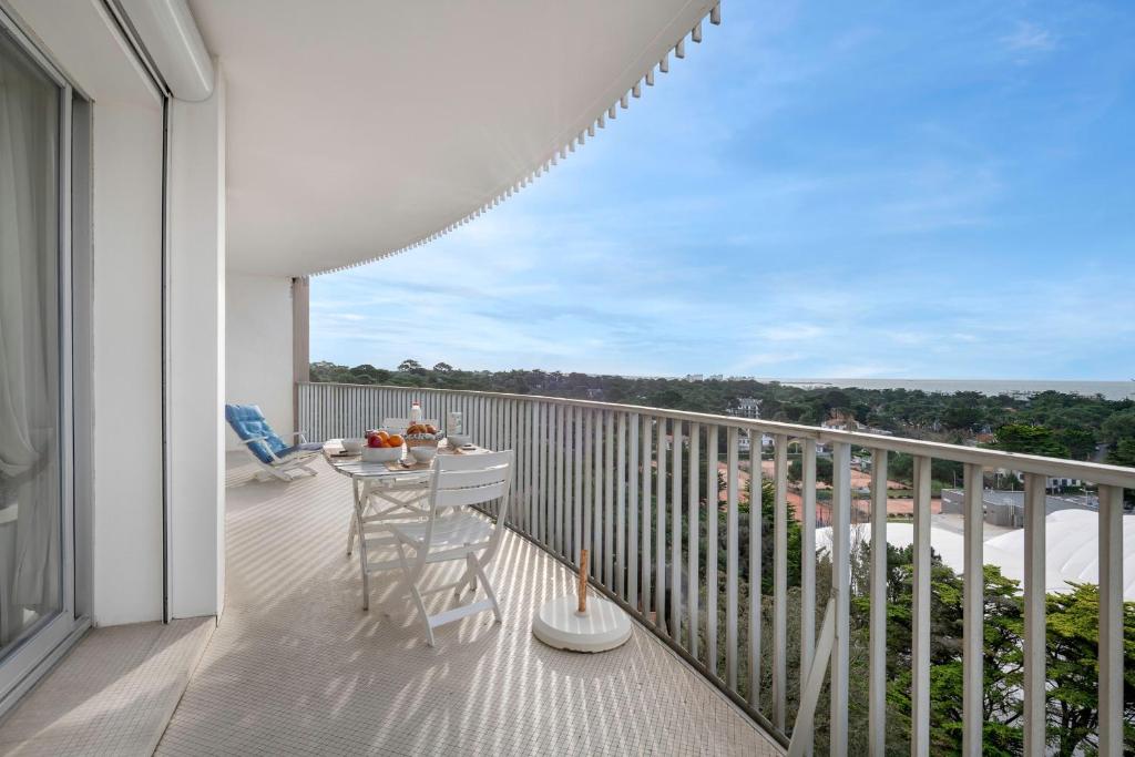 a balcony with a table and a view of the ocean at Sejour detente et panorama enchanteur in La Baule