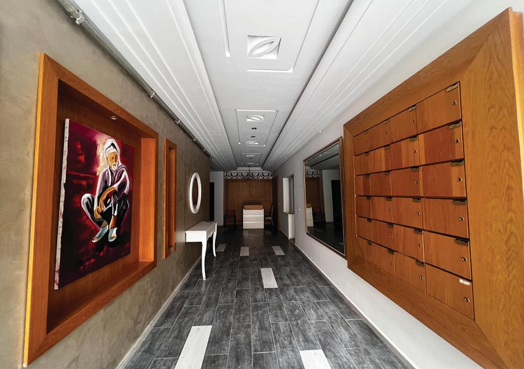 korytarz z drewnianymi szafkami i obrazem na ścianie w obiekcie Apartment in Sousse​ w Susie