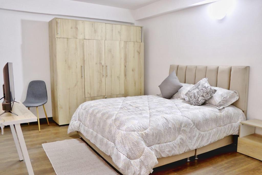 - une chambre avec un lit et une tête de lit en bois dans l'établissement Elegante/moderno/norte/valledeatriz, à Pasto