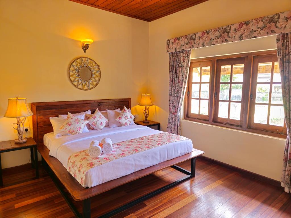a bedroom with a bed with two shoes on it at The Loris Manor in Nuwara Eliya
