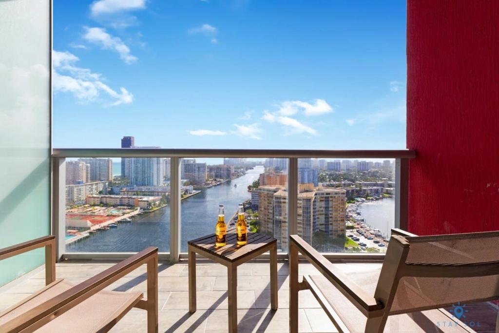 a balcony with two chairs and a view of a river at Infinite View with Balcony,Pool plus Near Beach in Hallandale Beach