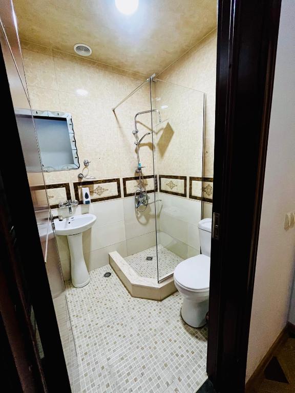 a bathroom with a shower and a toilet and a sink at Georgian Palace Hotel in Kutaisi