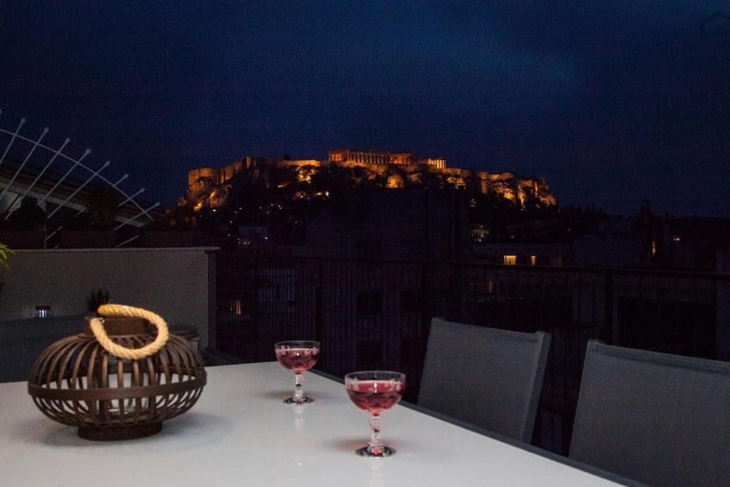 Breathtaking Acropolis Penthouse Ultimate Comfort في أثينا: طاولة مع كأسين من النبيذ وسلة
