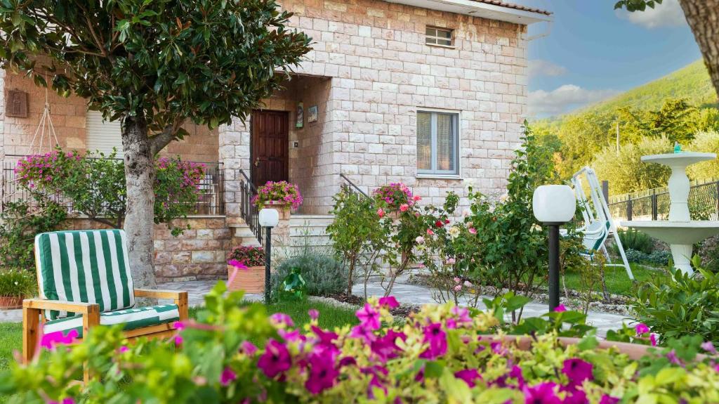 ein Haus mit zwei Stühlen und Blumen im Hof in der Unterkunft La Casa dei Fiori in Assisi