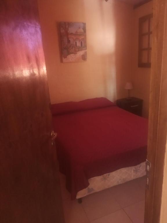 a bedroom with a red bed in a room at Brisas de montaña in Las Compuertas
