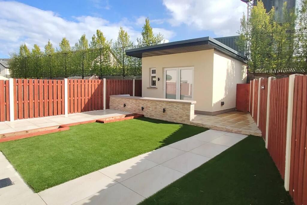 a small backyard with a fence and a lawn at Private Ensuite Room with Kitchenette in Phibblestown