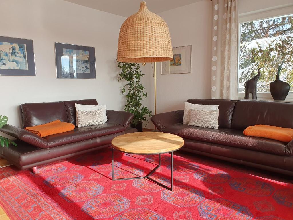 Una sala de estar con dos sofás de cuero y una mesa. en Ferienwohnung Aloisia, en Meersburg